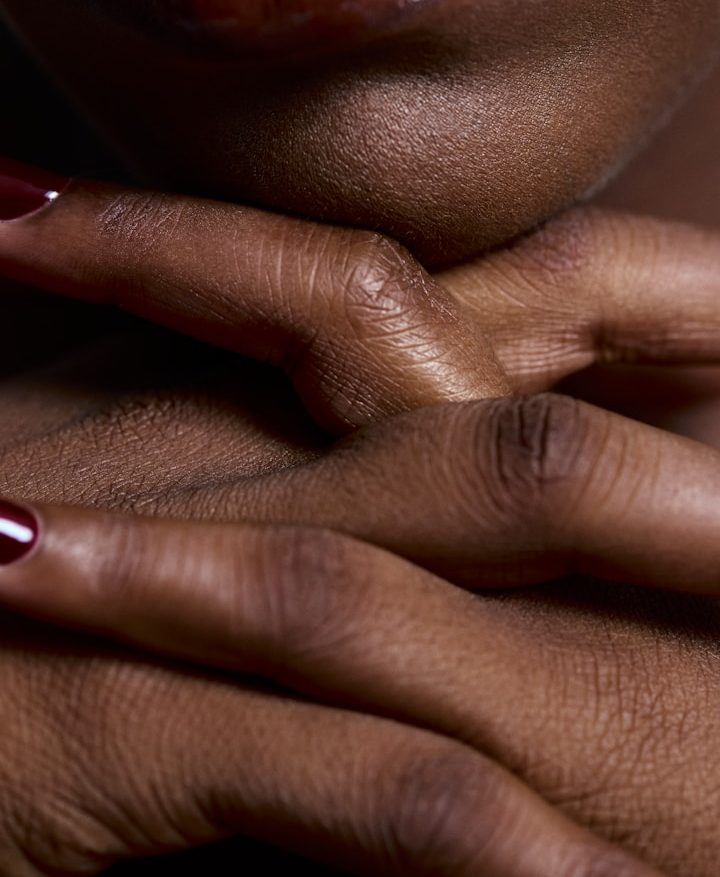 Tantra Massage + Essen Nahaufnahme von Händen mit kurz geschnittenen Nägeln und brauner Haut.